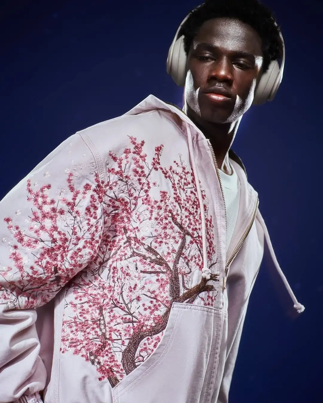 Vintage Y2K hoodie unisex with pink cherry blossom tree design worn by a man with headphones