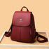 Functional leather-look backpack for daily use in maroon with front zippered pockets and adjustable straps