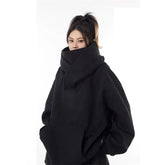 Black oversized Harajuku fashion hoodie unisex with high neck and front pocket worn by model