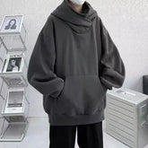 Black oversized Harajuku fashion hoodie unisex with front pocket and wide sleeves worn indoors