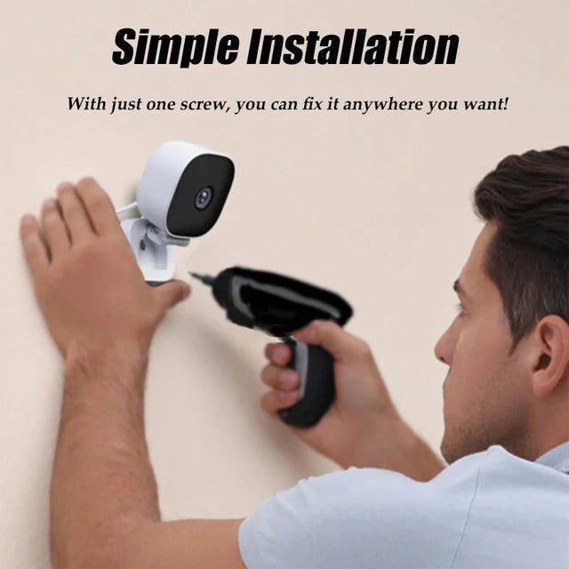 Man installing AngShop white indoor surveillance camera on wall using power drill for simple installation