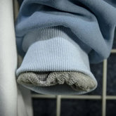 Close-up of light blue cute cat anime hoodie cuff showing soft inner lining and ribbed fabric texture