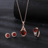 Elegant red tourmaline necklace and earrings set with gold and diamond accents on black background