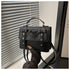 Elegant small PU leather bag in black with bow detail and top handle held near window blinds
