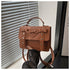 Elegant small PU leather bag in brown with bow and heart detail held in hand by window blinds