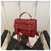 Elegant small PU leather bag in red with bow detail and adjustable strap by AngShop