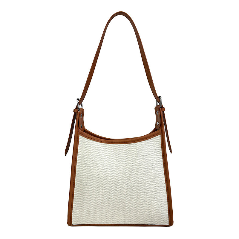 Elegant stitched handbag for women in white fabric with brown leather trim and shoulder strap