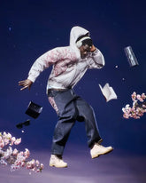 Man wearing a vintage Y2K hoodie unisex with floral design, dark jeans, and beige boots against a starry sky background
